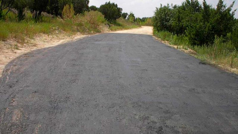 Dirt road coated with soil erosion control products